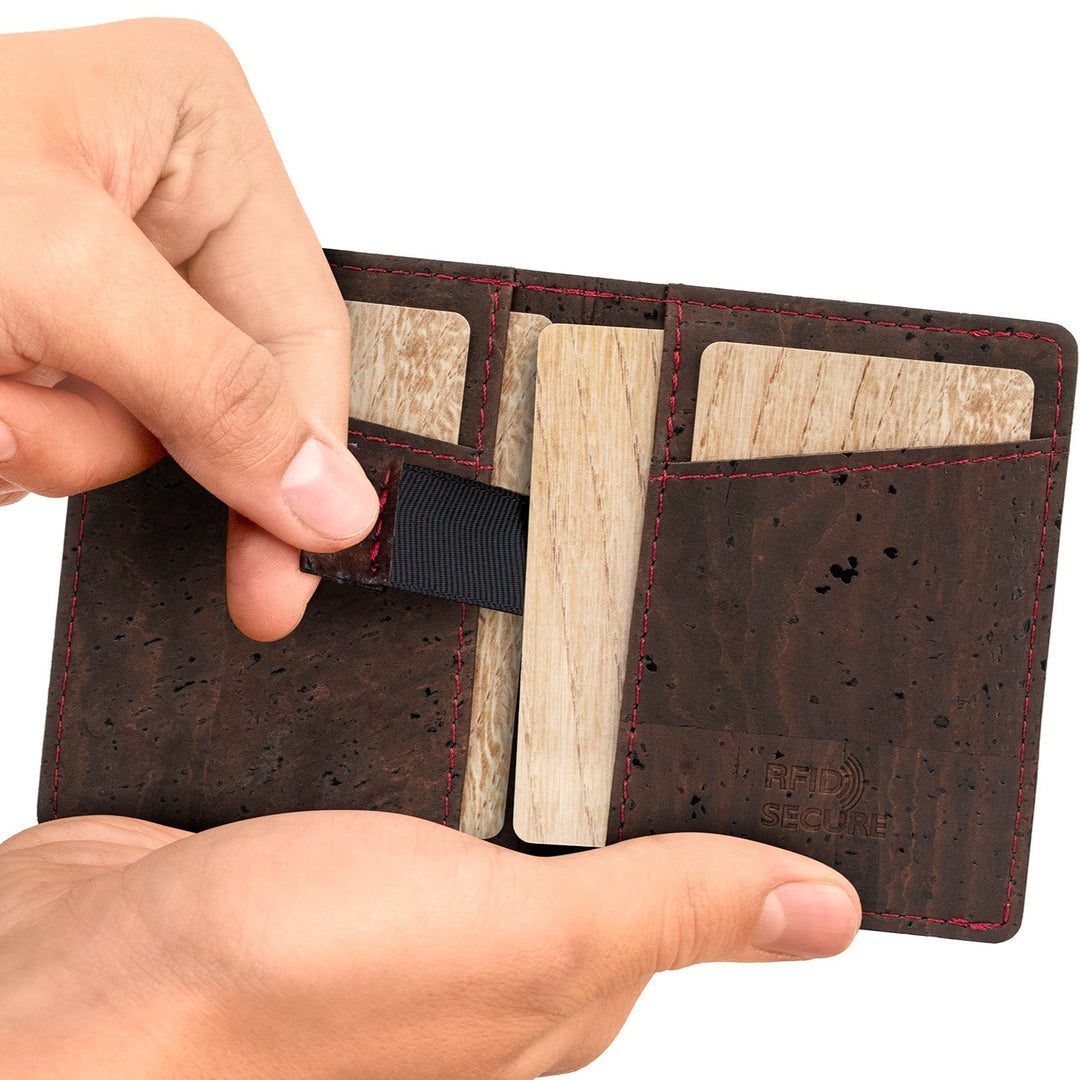 Hand zieht an Zugband eines Kartenfachs eines braunen Kartenetuis aus Kork