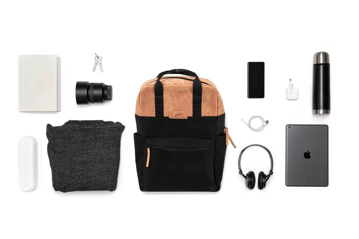 Collage mit schwarzem Rucksack mit hellen Korkteilen im Zentrum und ausgebreitetem Inhalt wie Kamera Equipment, Laptop, Trinkflasche etc. drum herum