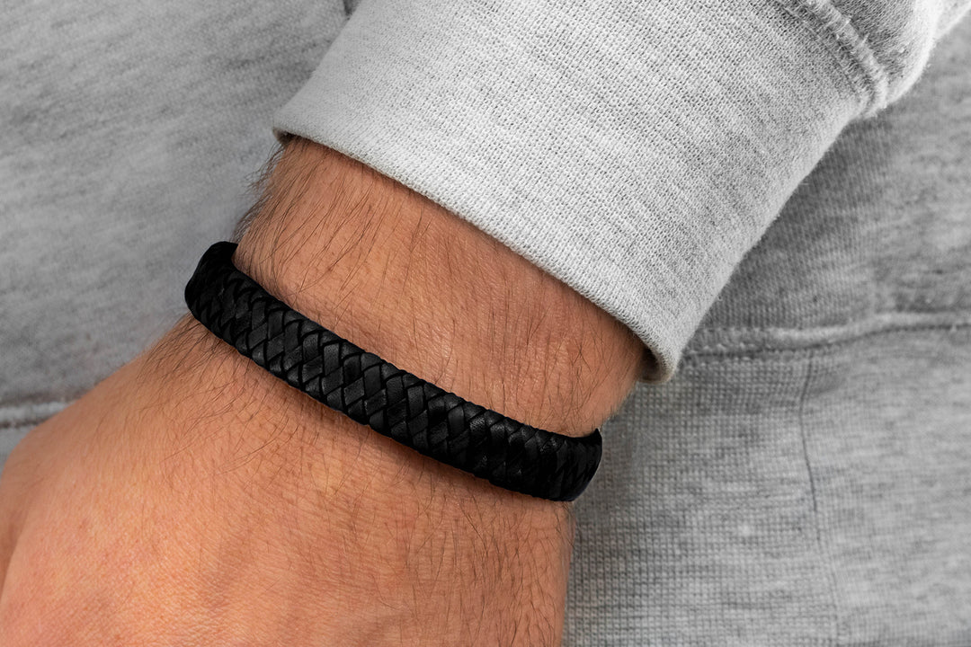 Breites, geflochtenes Lederarmband in schwarz an Herrenhandgelenk