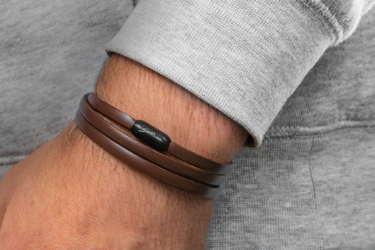 Herrenhandgelenk mit glattem. braunem Lederarmband mit schwarzem Magnetverschluss