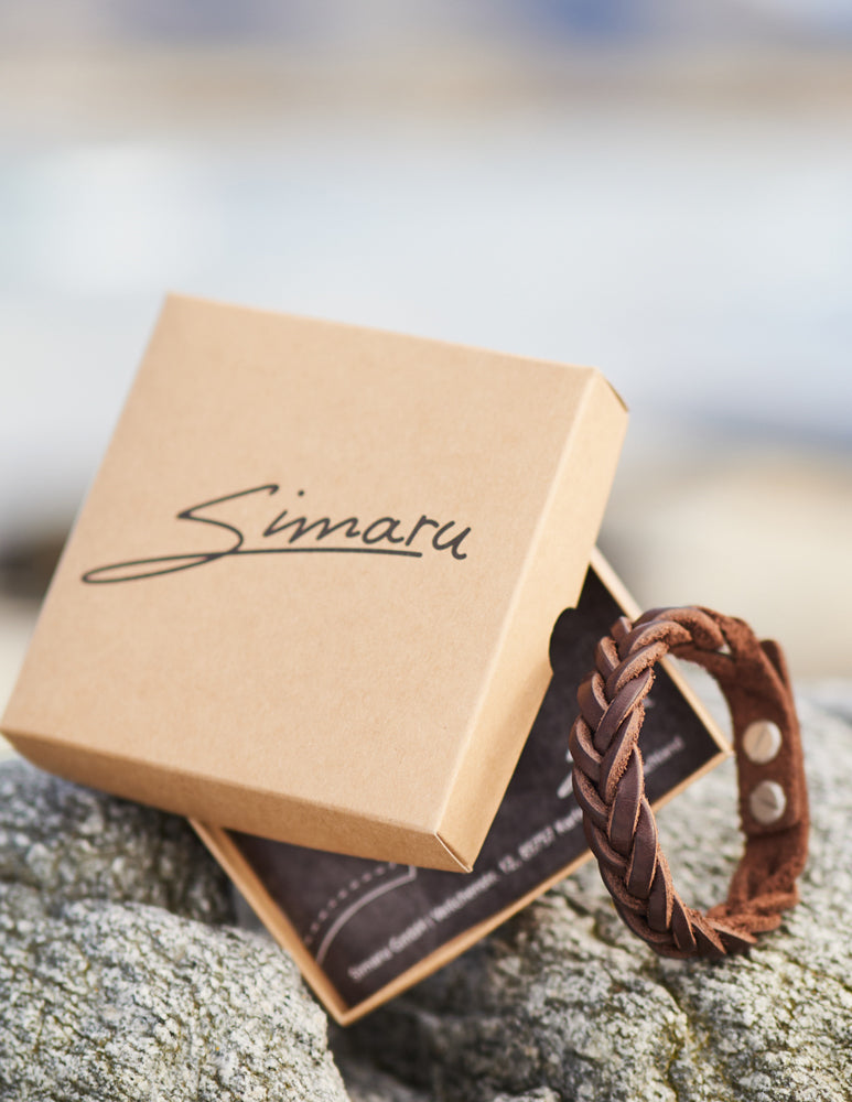Braunes geflochtenes Lederarmband neben Verpackungsbox mit Simaru Schriftzug