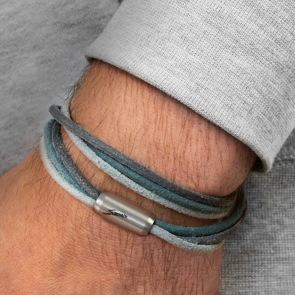 Blau-graues Lederarmband mit silbernem Magnetverschluss um Herrenhandgelenk gewickelt