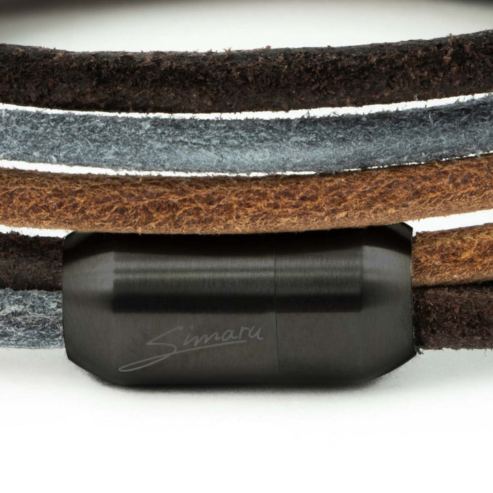 Großaufnahme schwarzer Magnetverschluss mit Simaru Schriftzug an mehrfarbigem Lederarmband