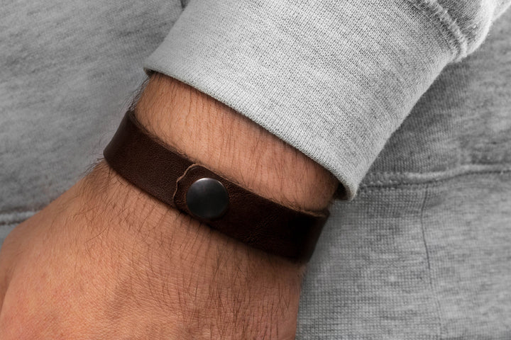 Breites, glattes Lederarmband in dunkelbraun mit Druckverschluss an Herrenhandgelenk #color_braun