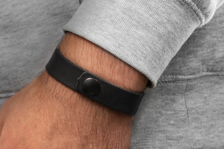 Breites, glattes Lederarmband in schwarz mit Druckverschluss an Herrenhandgelenk #color_schwarz