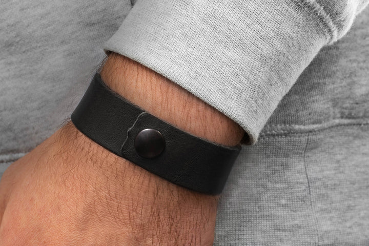 Breites, glattes Lederarmband in schwarz mit Druckverschluss an Herrenhandgelenk #color_schwarz