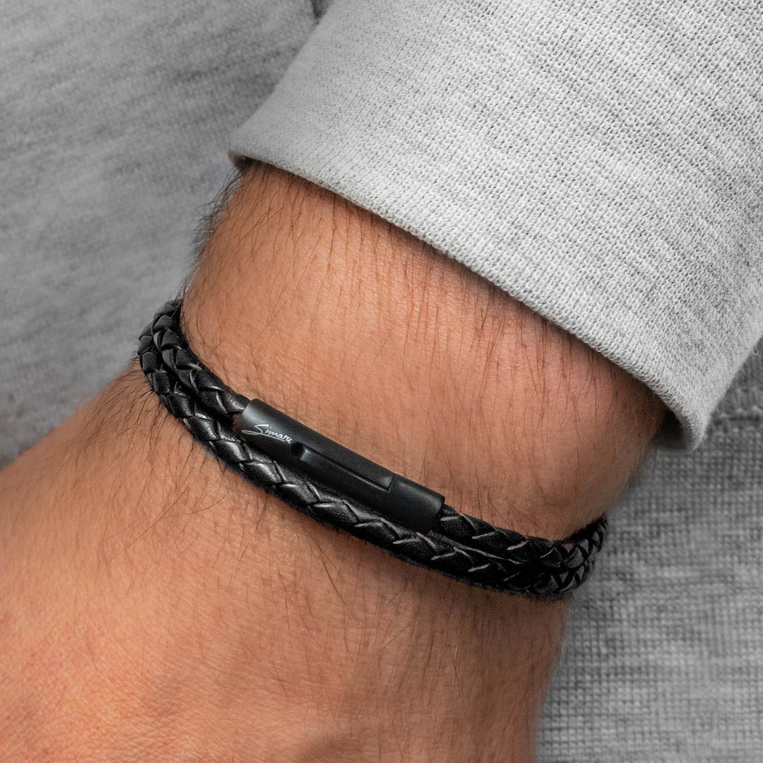 Schmales, geflochtenes Lederarmband in schwarz mit schwarzem Hakenverschluss um Herrenhandgelenk gewickelt