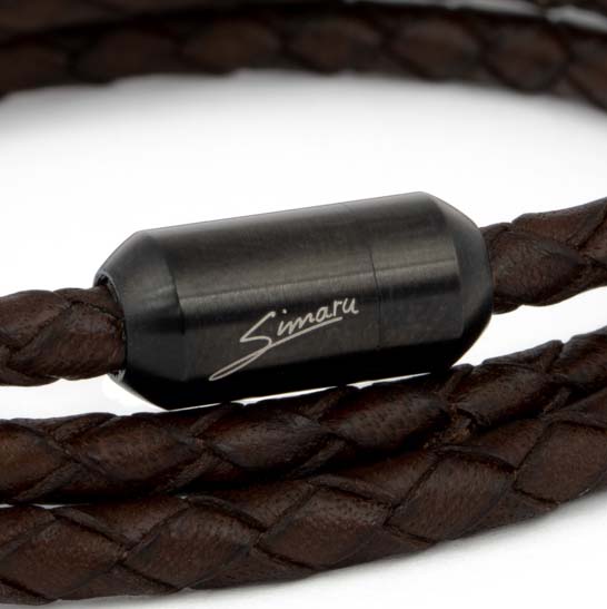 Großaufnahme schwarzer Magnetverschluss mit Simaru Schriftzug an geflochtenem, braunem Lederarmband