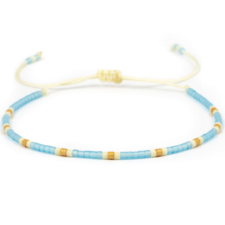 Armband mit einer Perlenreihe in hellblau, weiß und gold
