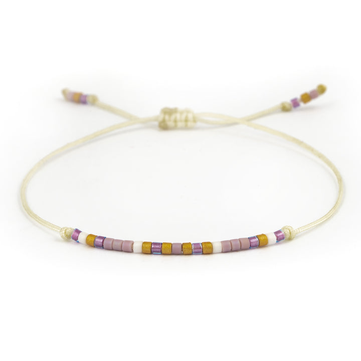 Armband mit einer halben Perlenreihe in lila, gold und weiß