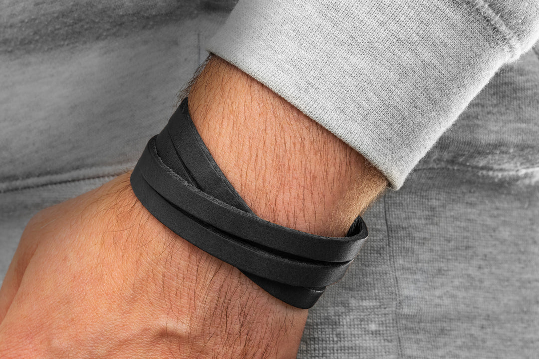 Schwarzes, glattes Lederarmband mehrfach um Herrenhandgelenk gewickelt