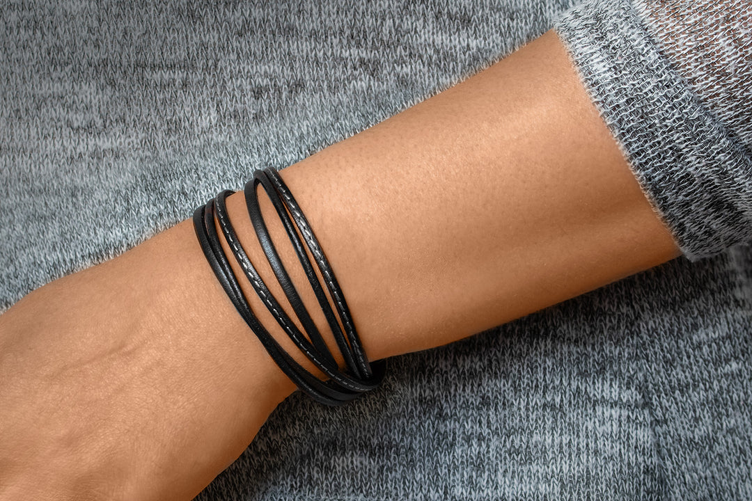 Glattes, schwarzes Lederarmband um Herrenhandgelenk gewickelt