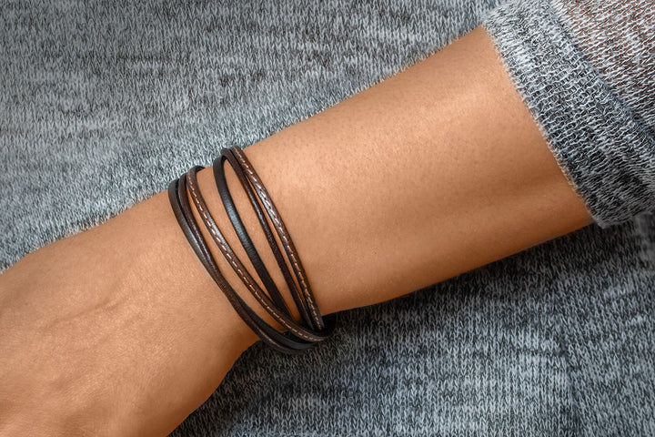Glattes, dunkles Lederarmband um Herrenhandgelenk gewickelt