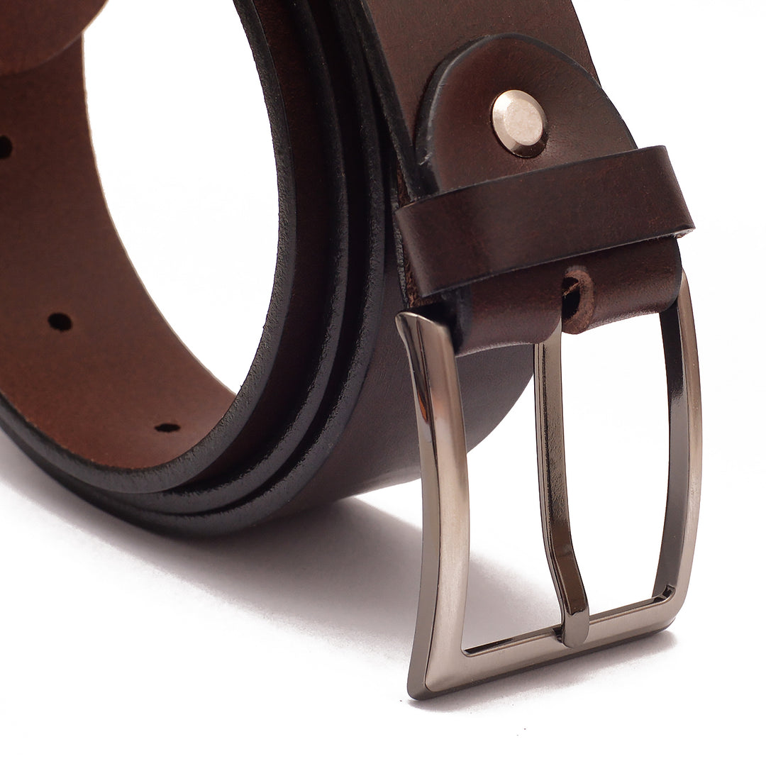 Nahaufnahme silberne Gürtelschnalle an aufgerolltem Gürtel aus braunem Leder #color_braun