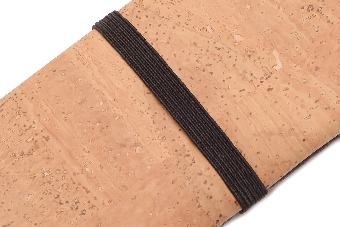 Nahaufnahme schwarzer Gummibandverschluss um heller Kork-Tabaktasche #color_anthrazit-natur