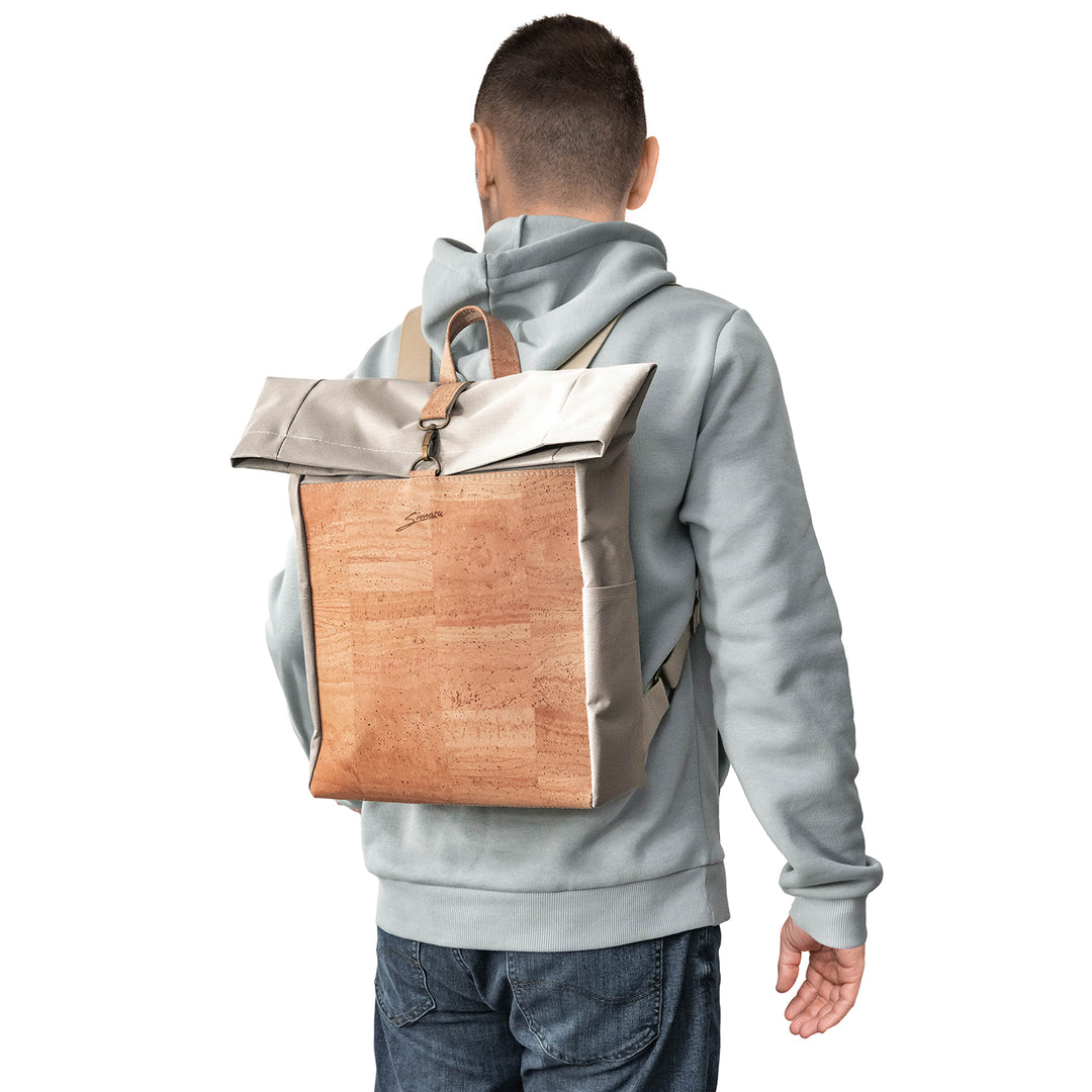 Rückansicht junger Mann mit hellem Pullover und Rucksack aus weißem Stoff mit heller Korkfront auf dem Rücken