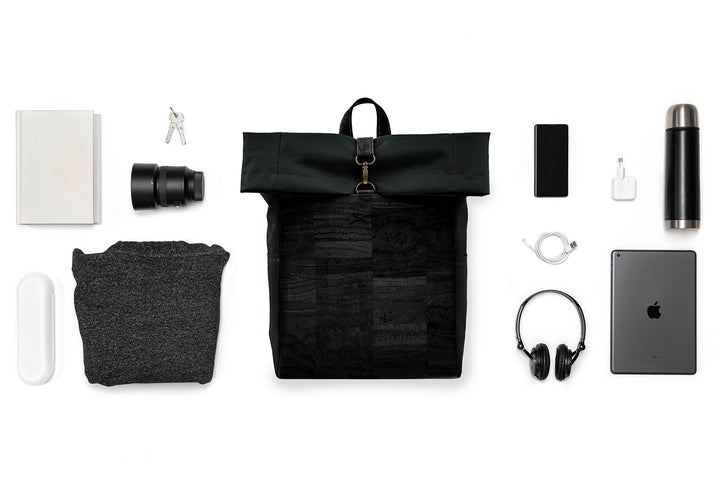 Collage mit schwarzem Toploader Rucksack mit schwarzer Korkfront im Zentrum und ausgebreitetem Inhalt wie Kamera Equipment, Laptop, Trinkflasche etc. drum herum 