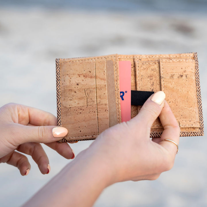 Hand zieht am Zugband für Kartenfach eines geöffneten Kork-Geldbeutels #color_vinicunca