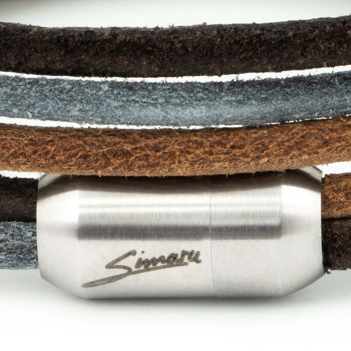 Großaufnahme silberner Magnetverschluss mit Simaru Schriftzug an Wickelarmband aus rauem Leder