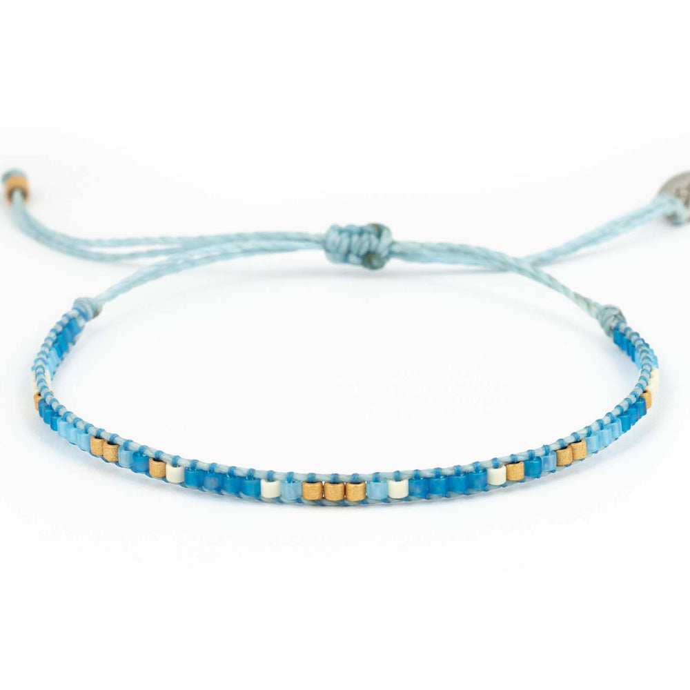 Einfaches, blaues Perlenarmband mit einzelnen Perlen in gold und weiß
